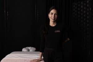 Woman smiling standing beside a massage table